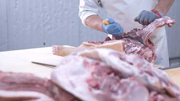 Fleischverarbeitung eine Person, die Fleisch mit einem Messer schneidet