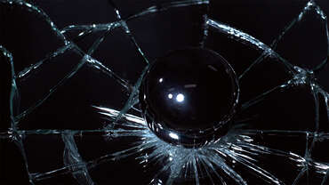Impactinator® Glass - Vidrio que fortalece una bola de vidrio sobre una superficie negra
