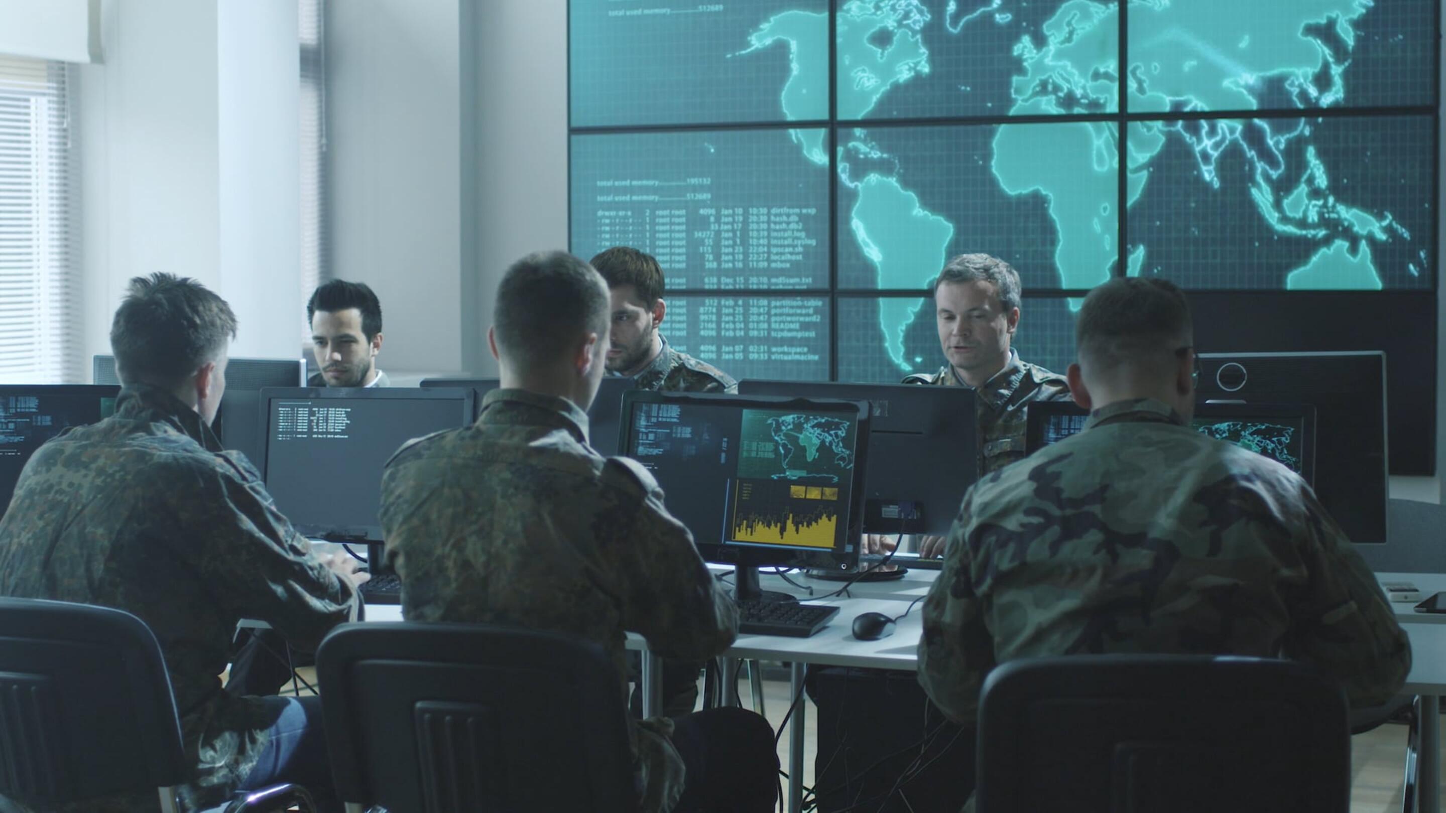 Tempest - Tempest um grupo de homens com uniformes militares sentados em computadores